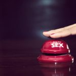 woman's hands press sex bell on a reception bell. concept about sex and eroticism